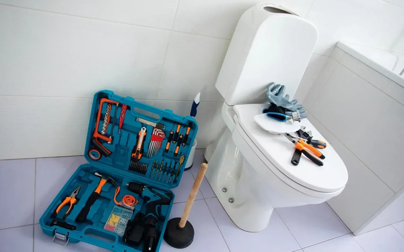 Outils et ventouse posés près d'un WC lors d'un débouchage à Aulnay-sous-Bois